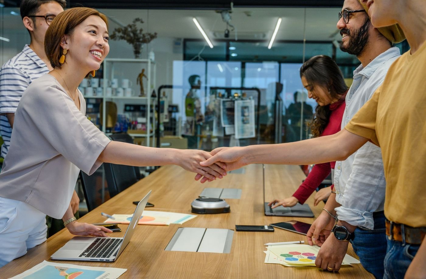 Colleagues collaborate around a table in a modern office.