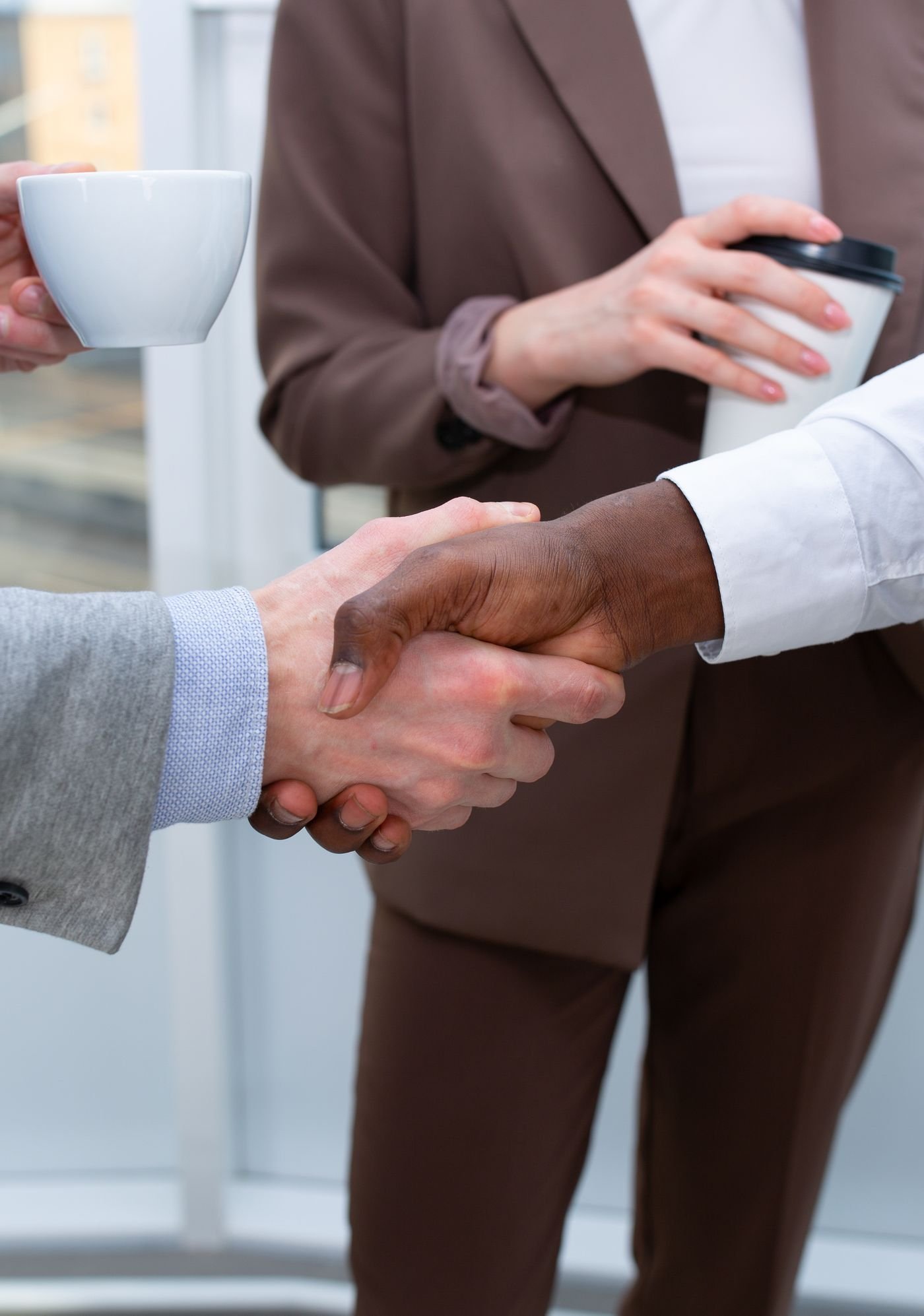 Business partners shaking hands across a meeting table
