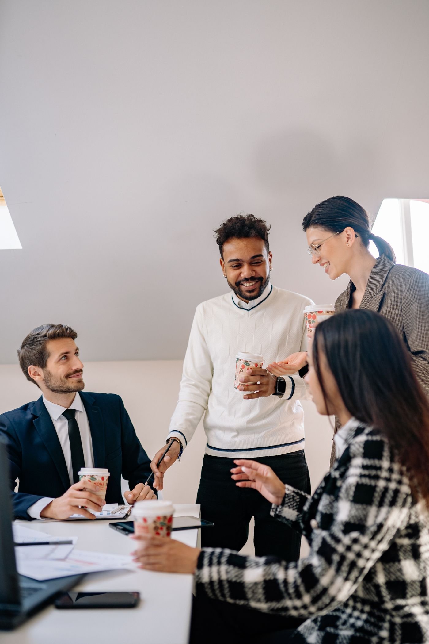 Smiling business partners share a conversation over coffee.