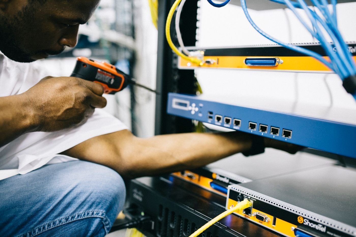 A technician uses a power tool while working on hardware.