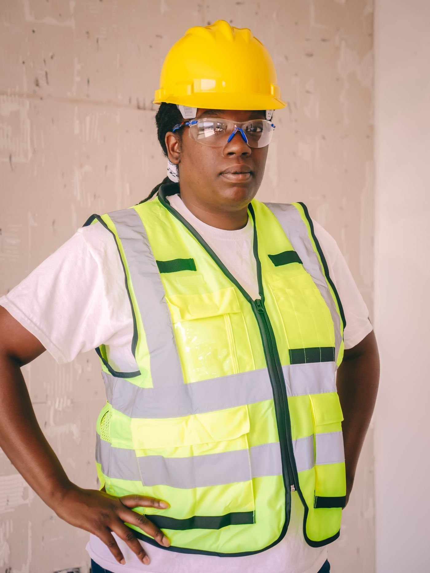 A construction professional wears a hard hat and protective vest.