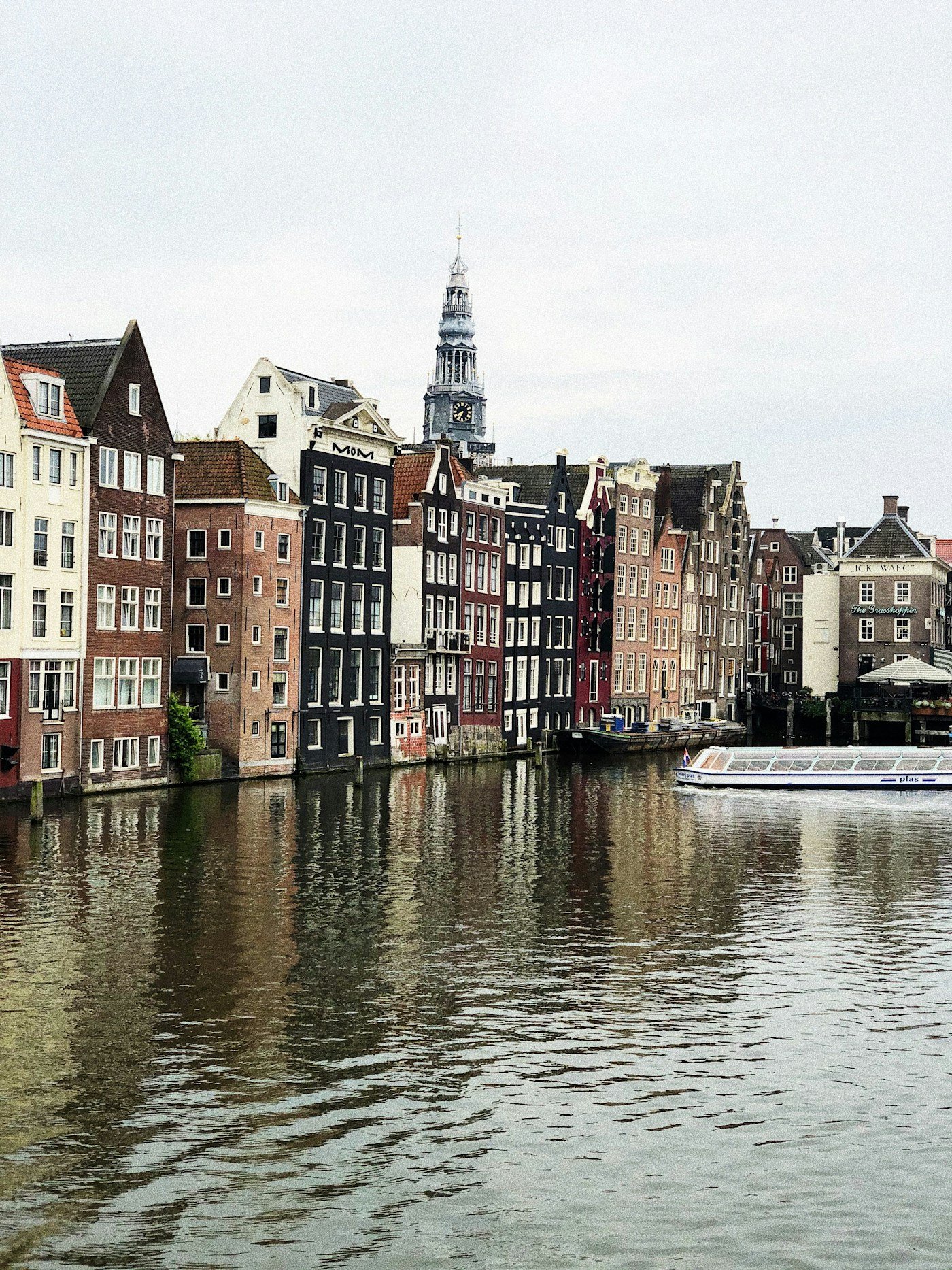 Gabled canal houses and tour boat on Amsterdam waterway