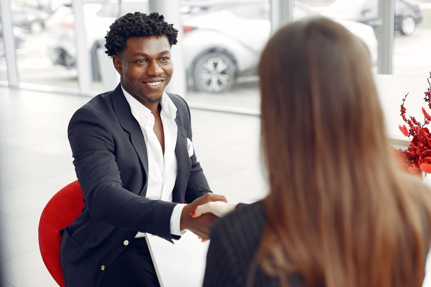 Smiling Black businessman shakes hands with a business partner