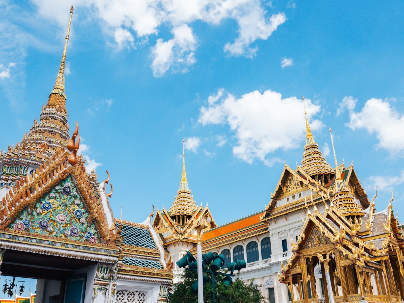 Ornate Thai temple roofs and golden spires under blue sky